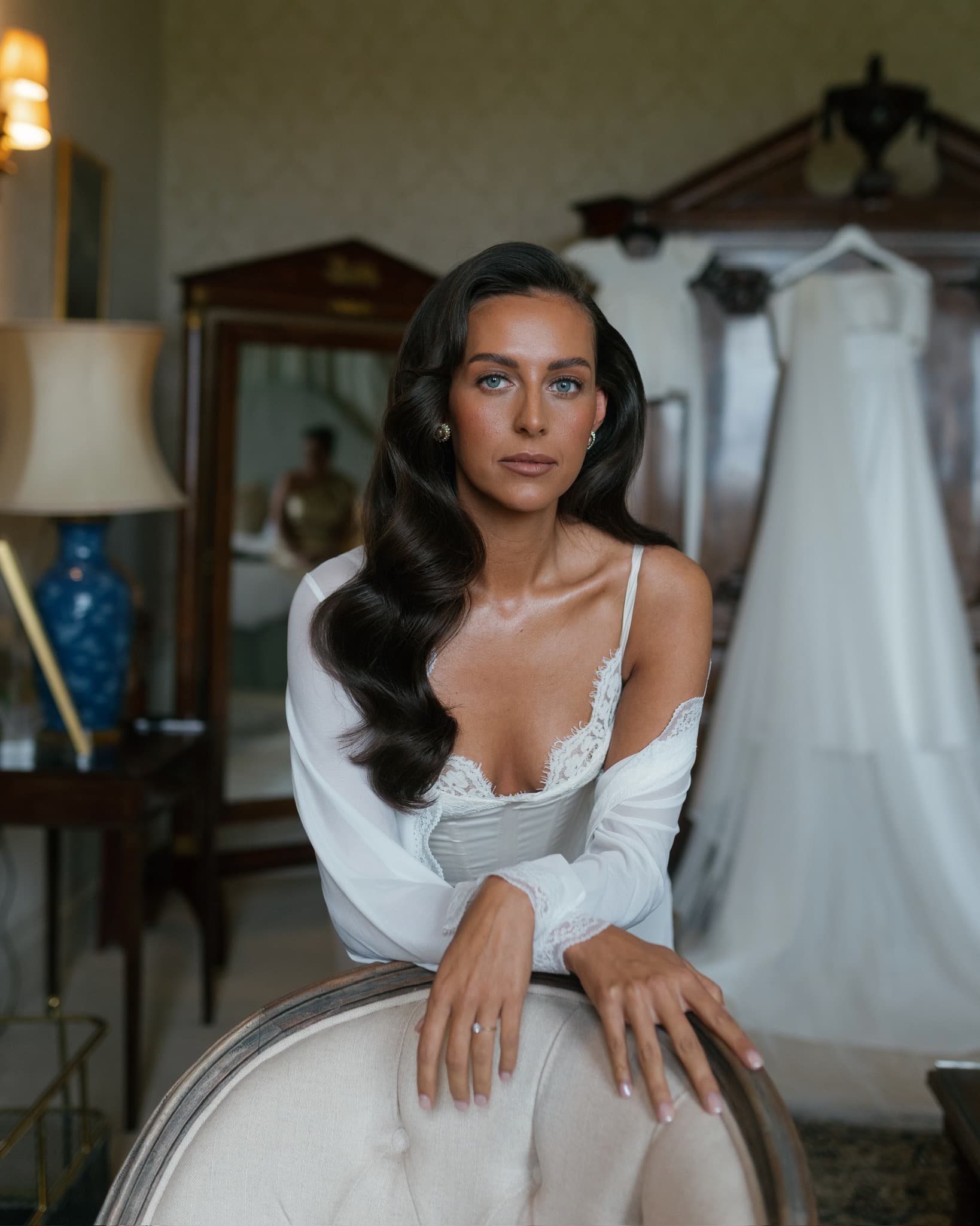 Bride with glossy Hollywood waves in a softly lit room